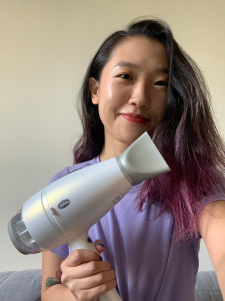 A selfie of Allure senior commerce writer Sarah Han holding the Drybar Reserve Ultralight AntiFrizz BlowDryer