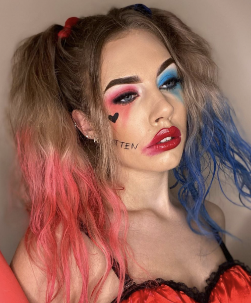 Portrait of woman wearing blue and red makeup