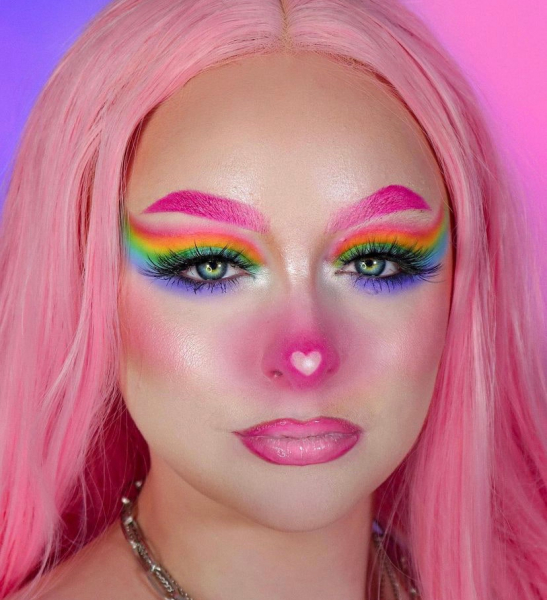 Portrait of a woman wearing rainbow eyeshadow and pink makeup