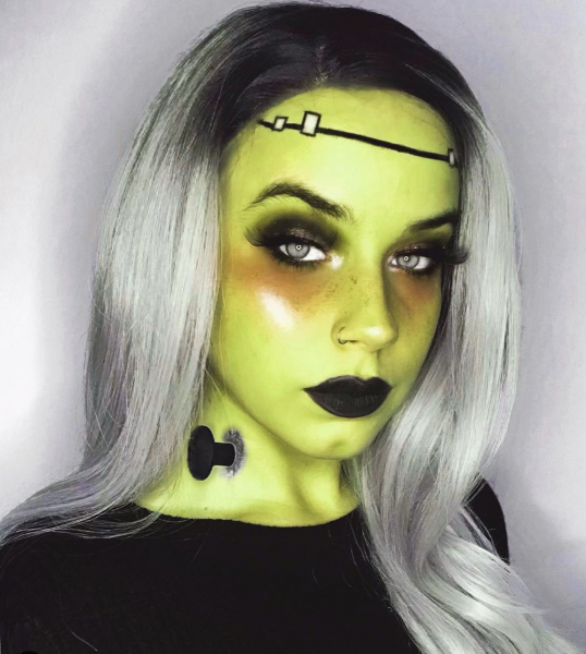 Portrait of woman wearing green and black makeup
