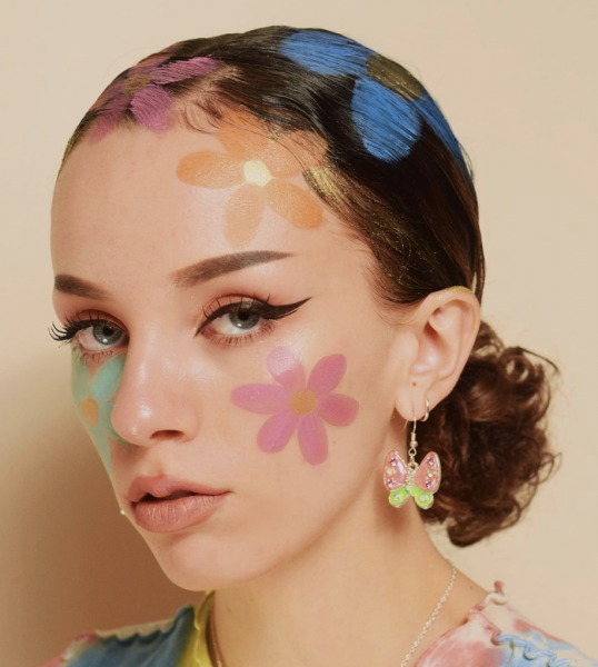Portrait of a woman wearing flowers on her face and hair