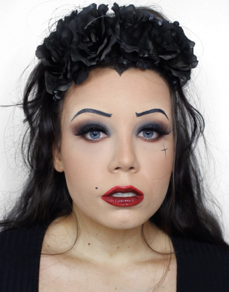 Portrait of a woman wearing dark black makeup and red lipstick
